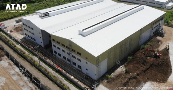 Un grande edificio per uffici in struttura in acciaio prefabbricato con tetto a scorciatoia e fondazione in cemento